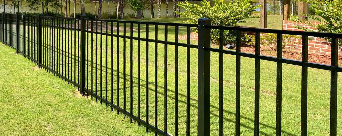 Black aluminum fence around a green yard
