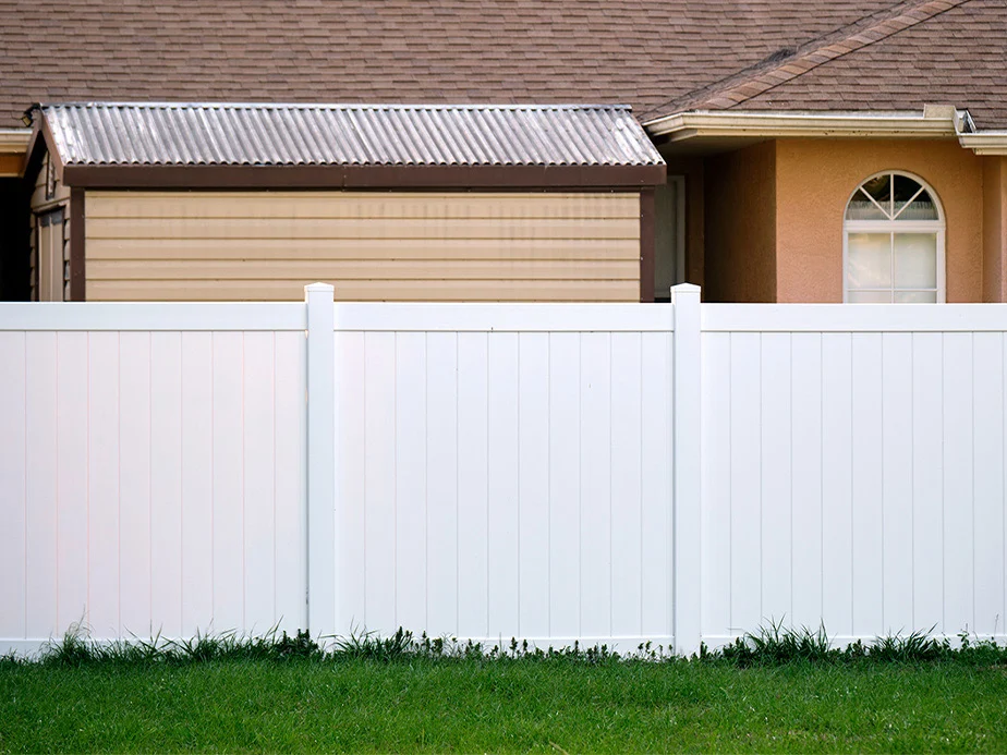 White vinyl privacy fence beside a home