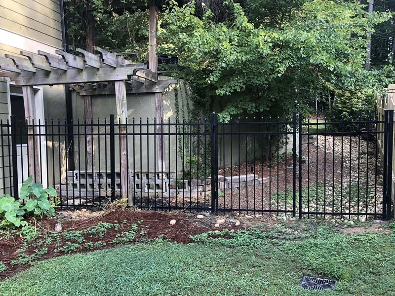 Open metal fencing beside a garden pergola