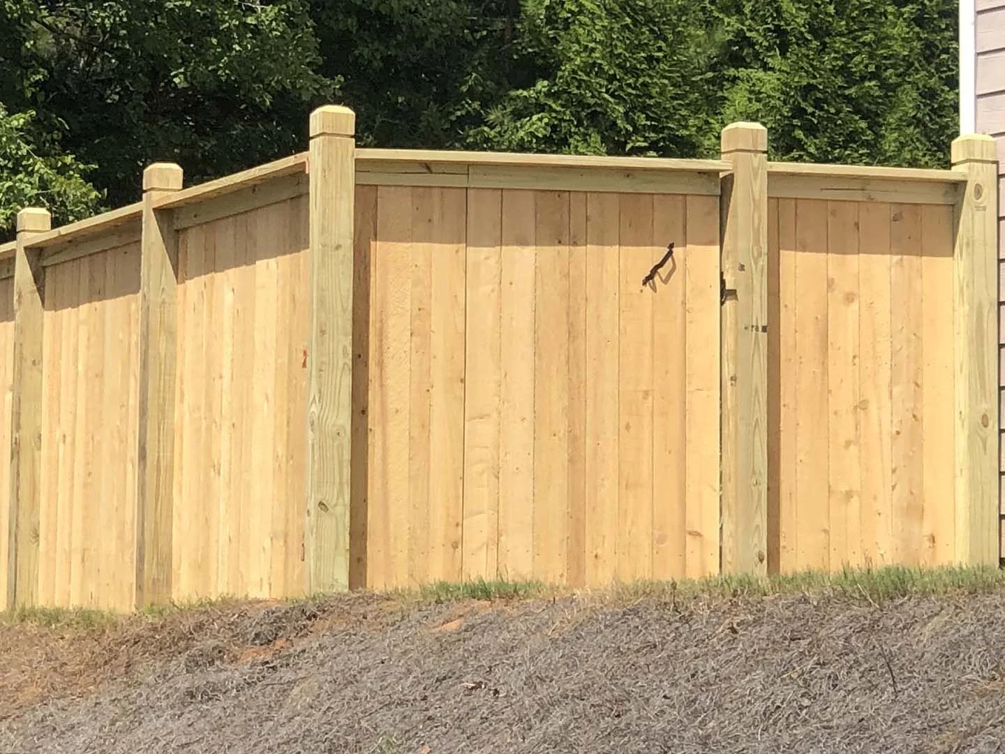 Capped wood walk gate between finished posts