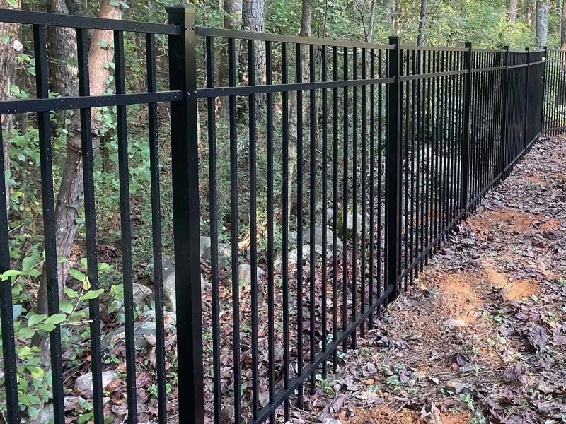 Metal fence following a wooded boundary