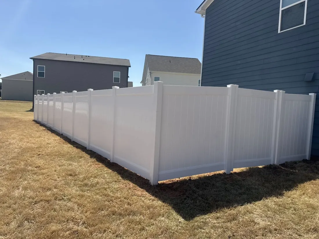 White vinyl privacy fence beside a home